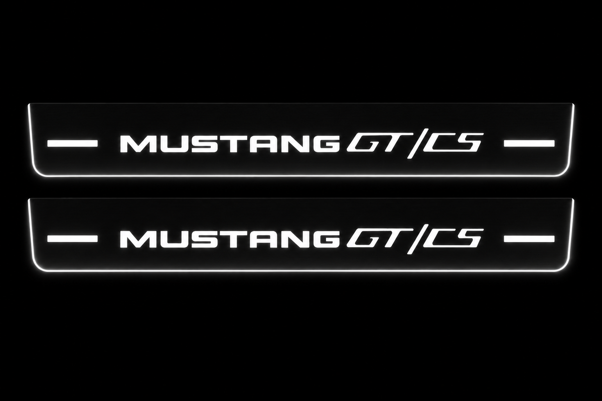 Product visualization: two flat Mustang GT/CS front sill plates, exact current v3 MUSTANG and GT/CS artwork. Black night background, unlit stainless face nearly hidden, white illuminated artwork, bars and real side/end edges with soft glow.