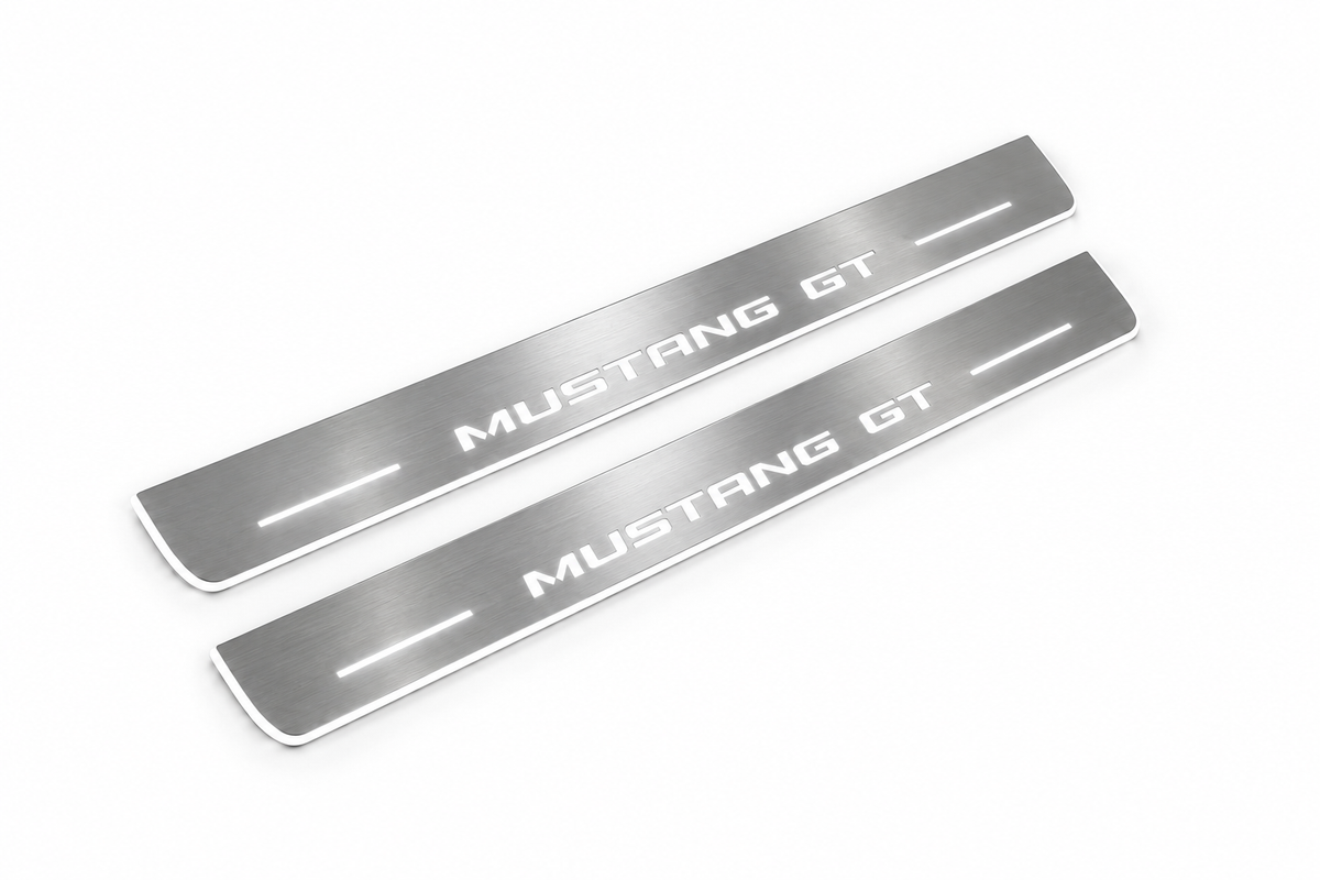 Product visualization: mustang-gt-s550 exact MUSTANG GT source artwork, two flat front plates flat brushed stainless steel door sill plates with white LED artwork and edges, white background.