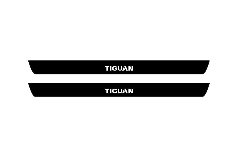 Catalog illustration of two black front door sill plates with Tiguan lettering.