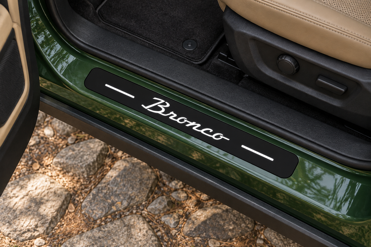 Product visualization of a black Matte PRO sill in a green Bronco-type doorway, white cursive Bronco lettering and two top bars, with unlit edges.