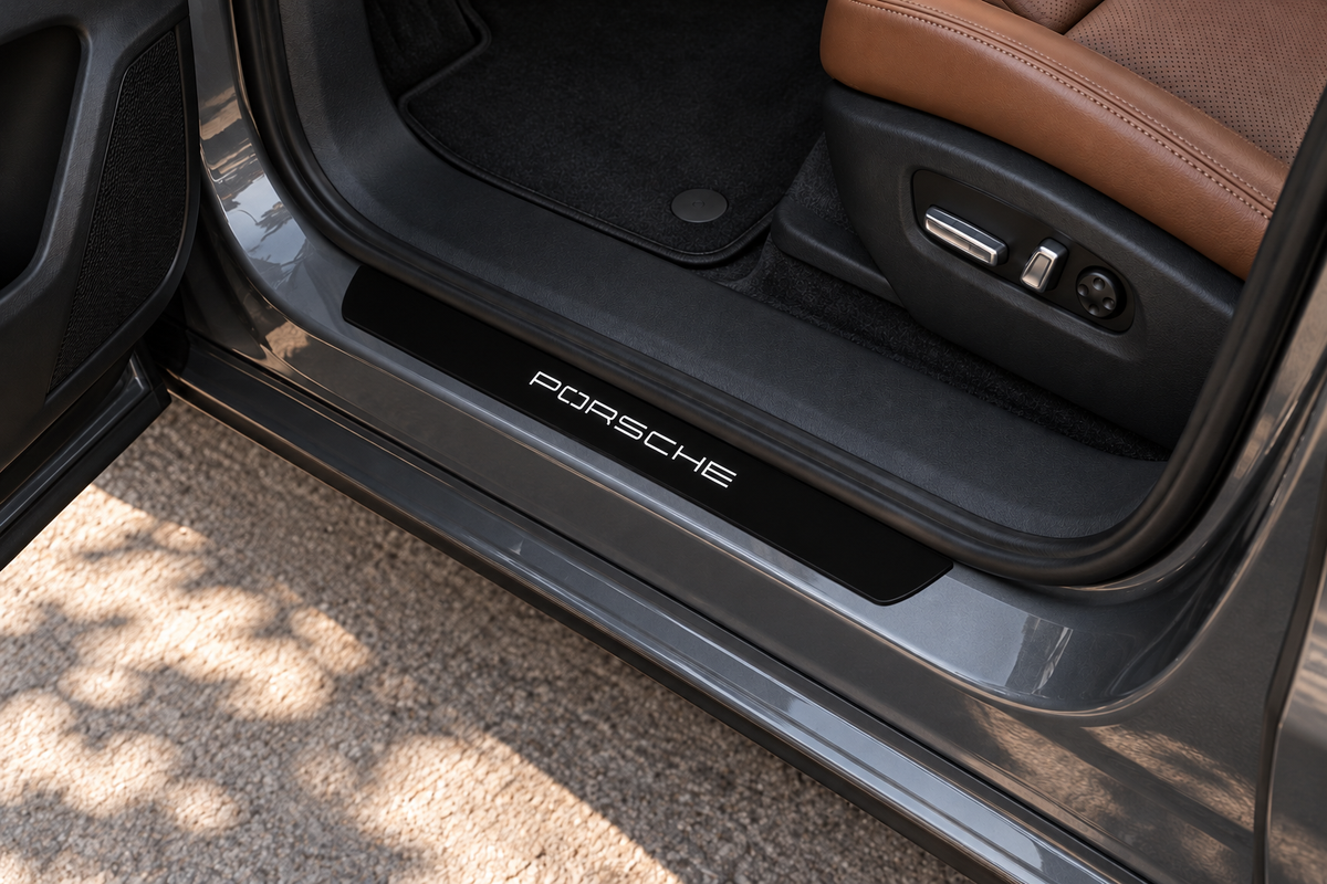 Cayenne 9Y0 Matte PRO sill on graphite metal directly against rubber seal; white geometric PORSCHE lettering, edges unlit — product visualization