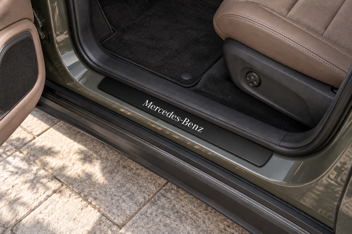 Mercedes-Benz GLE W167 Matte PRO sill visualization on the existing exposed olive-grey metal threshold, inner edge directly against the rubber seal, white Mercedes-Benz lettering and dark unlit edges.