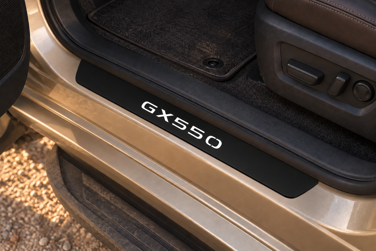 Lexus GX550 Matte PRO sill visualization on an exposed bronze metal threshold, inner edge directly against the rubber seal, white GX550 lettering and dark unlit edges.