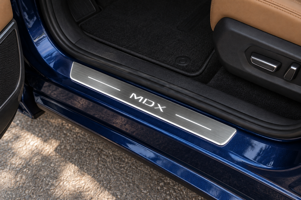 Product visualization of a grey stainless MDX door sill with white lettering, two thin light bars and a lit edge on a blue SUV threshold with tan interior.