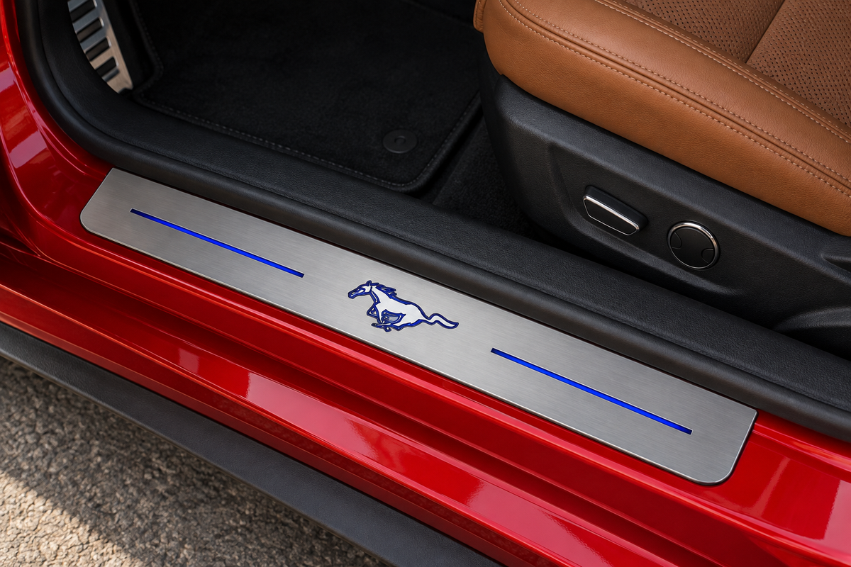 Product visualization of a grey stainless running-horse sill with blue artwork and two blue bars on a red coupe doorway beside a saddle leather seat.