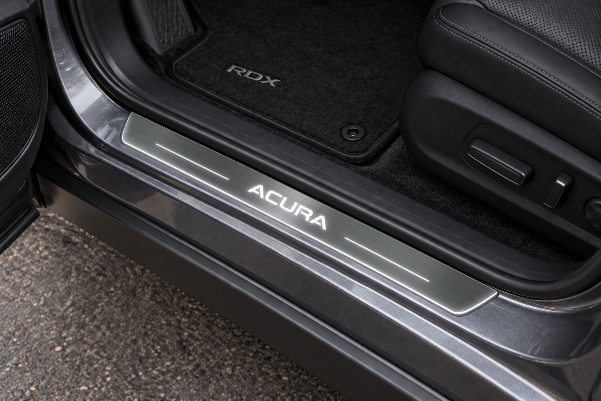 Product visualization of an Acura RDX III doorway with brushed stainless steel sill, white ACURA lettering, two light bars and a thin illuminated lower edge.