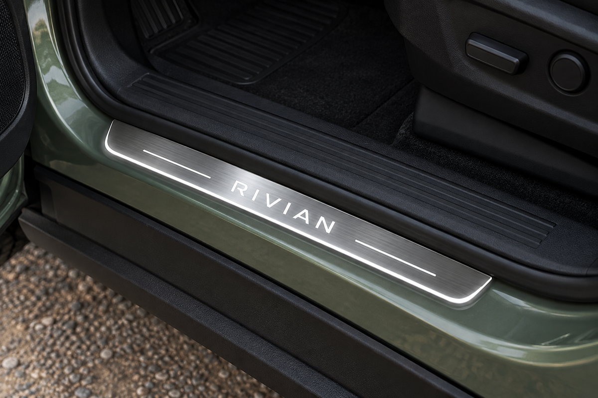 Rivian R1T Stainless Steel door sill visualization: RIVIAN lettering, two side bars and thin edge lit white on a grey brushed plate in a green pickup doorway.