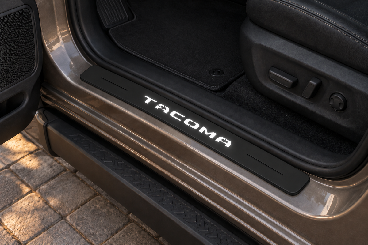 Toyota Tacoma N400 Matte PRO sill visualization directly against the rubber seal on exposed bronze metal, segmented white TACOMA lettering and dark decorative lines.