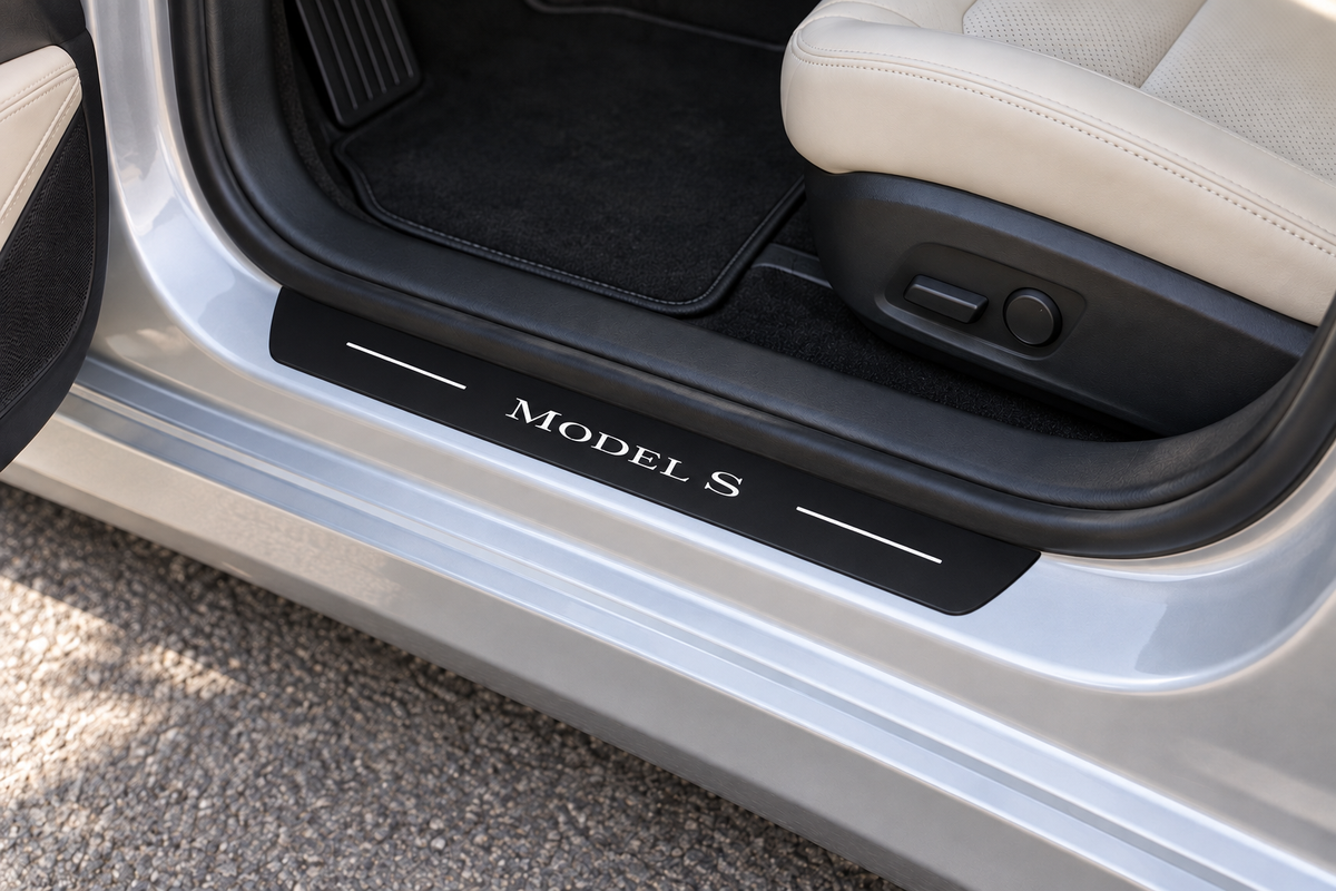 Tesla Model S Matte PRO sill visualization directly against the rubber seal on exposed silver metal, white Model S lettering and two thin white top bars, dark edges.