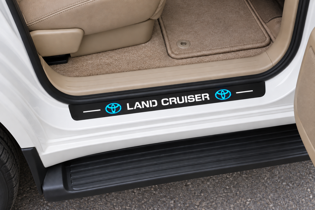 Toyota Land Cruiser J200 Matte PRO sill visualization directly against the rubber seal on exposed white metal, LAND CRUISER lettering, blue emblems and white bars, dark edges.