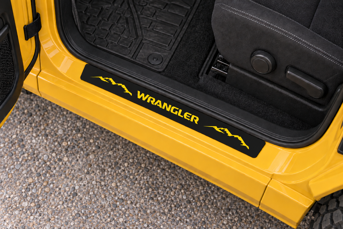 Jeep Wrangler black-coated Stainless sill visualization as a separate rigid plate on the upper yellow metal threshold, meeting the rubber seal directly, with yellow WRANGLER lettering and mountain artwork.