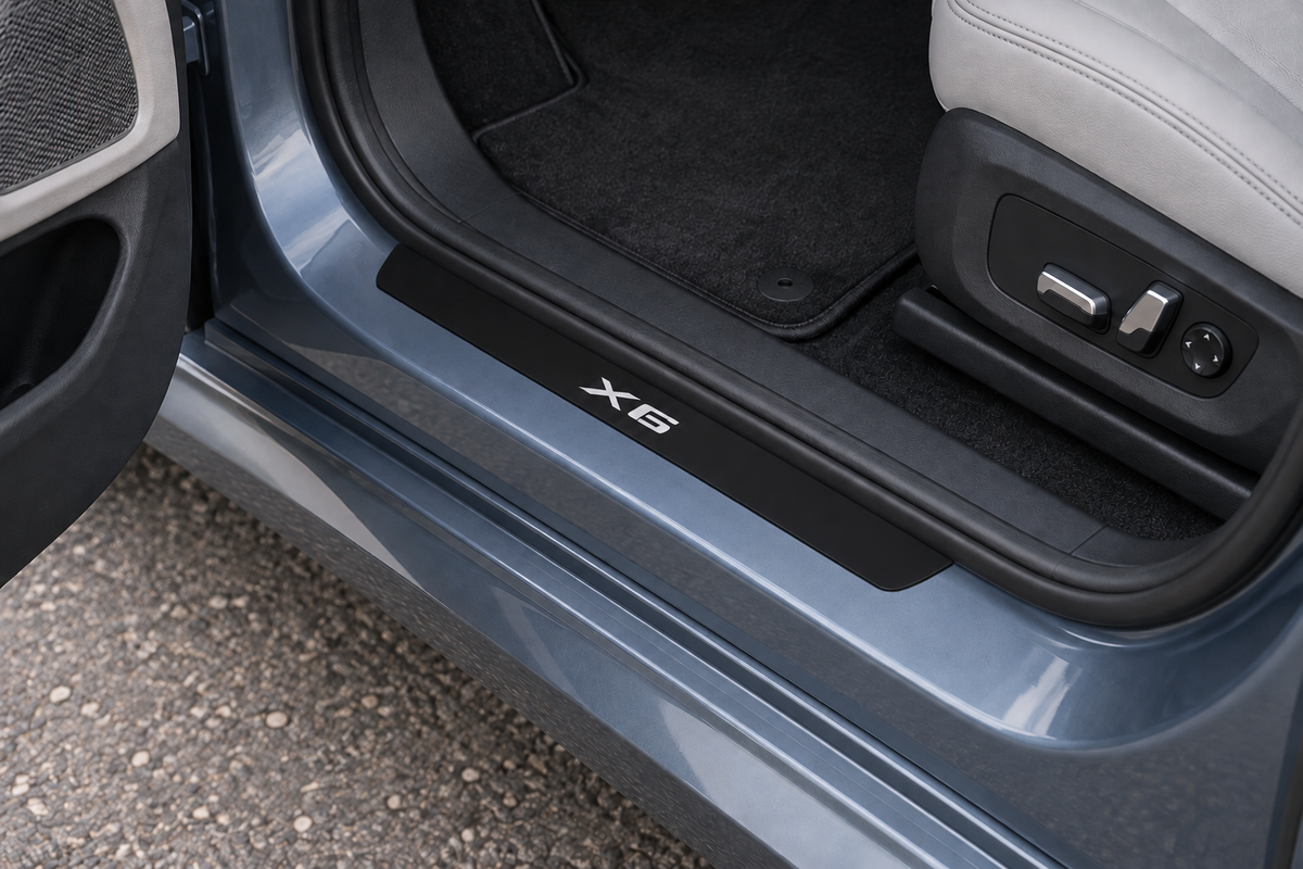 BMW X6 G06 Matte PRO sill visualization directly against the rubber seal on exposed silver-blue metal, white X6 lettering and dark edges.
