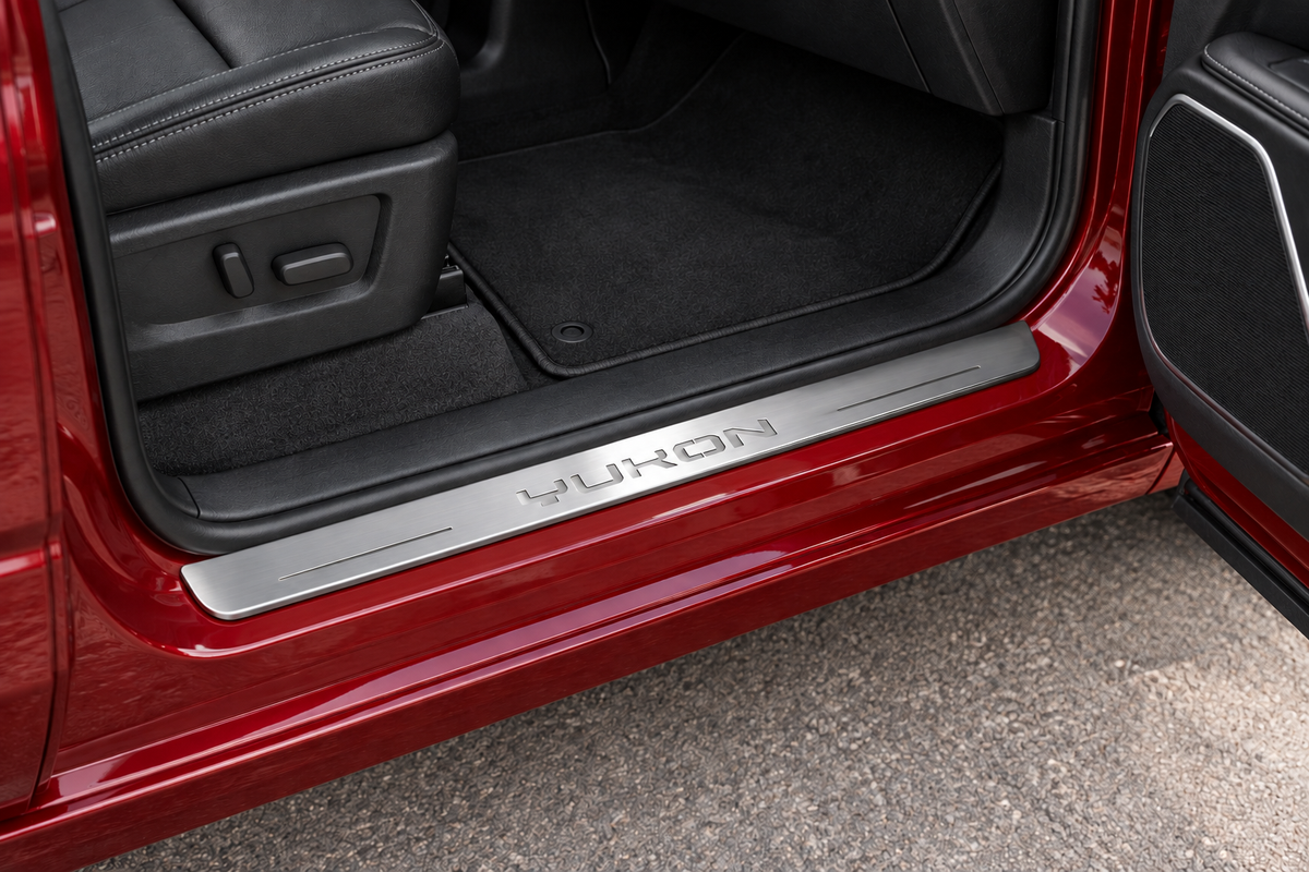 GMC Yukon Stainless sill visualization in an unlit state, directly against the rubber seal on exposed red metal, with YUKON lettering and two thin source bars.