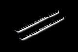 Two long door sill plates with Evoque lettering and edges illuminated in white, angled view on a dark background.