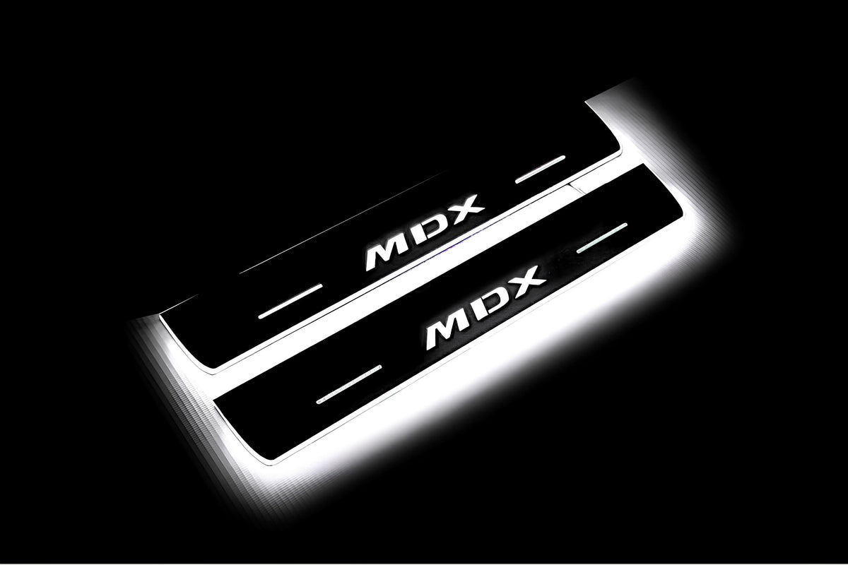 Two short door sill plates with MDX lettering and edges illuminated in white, angled view on a dark background.