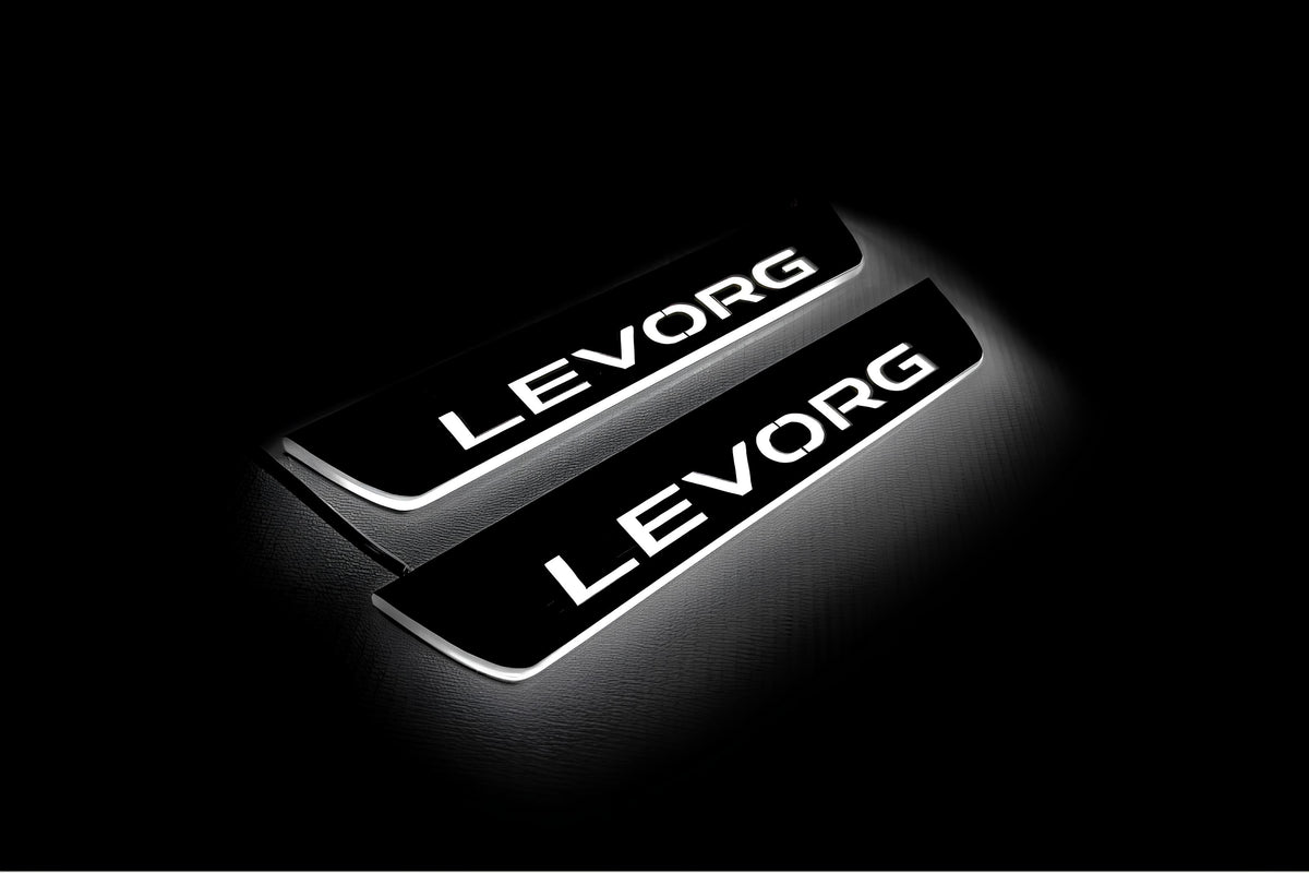 Two short door sill plates with Levorg lettering and edges illuminated in white, angled view on a dark background.