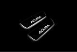 Two short door sill plates with Acura lettering and edges illuminated in white, angled view on a dark background.