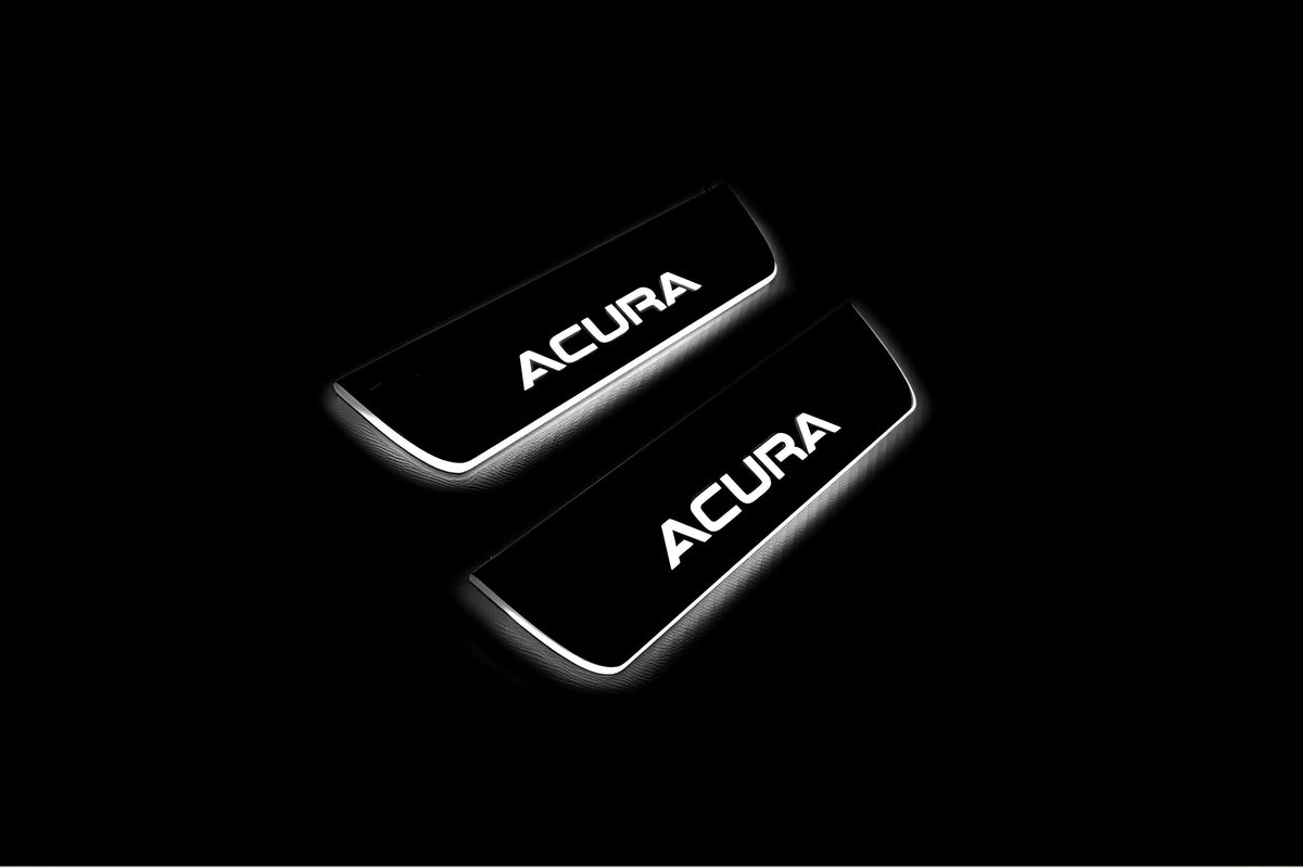 Two short door sill plates with Acura lettering and edges illuminated in white, angled view on a dark background.