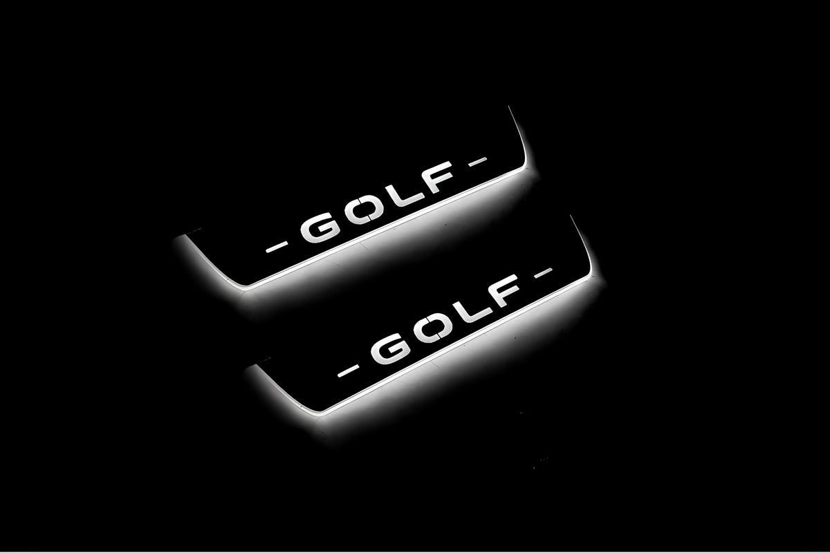 Two short door sill plates with Golf lettering and edges illuminated in white, angled view on a dark background.