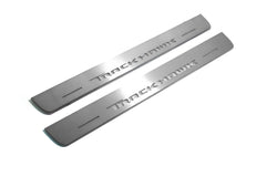Two long silver-finished door sill plates with Trackhawk lettering on a light background, angled view.