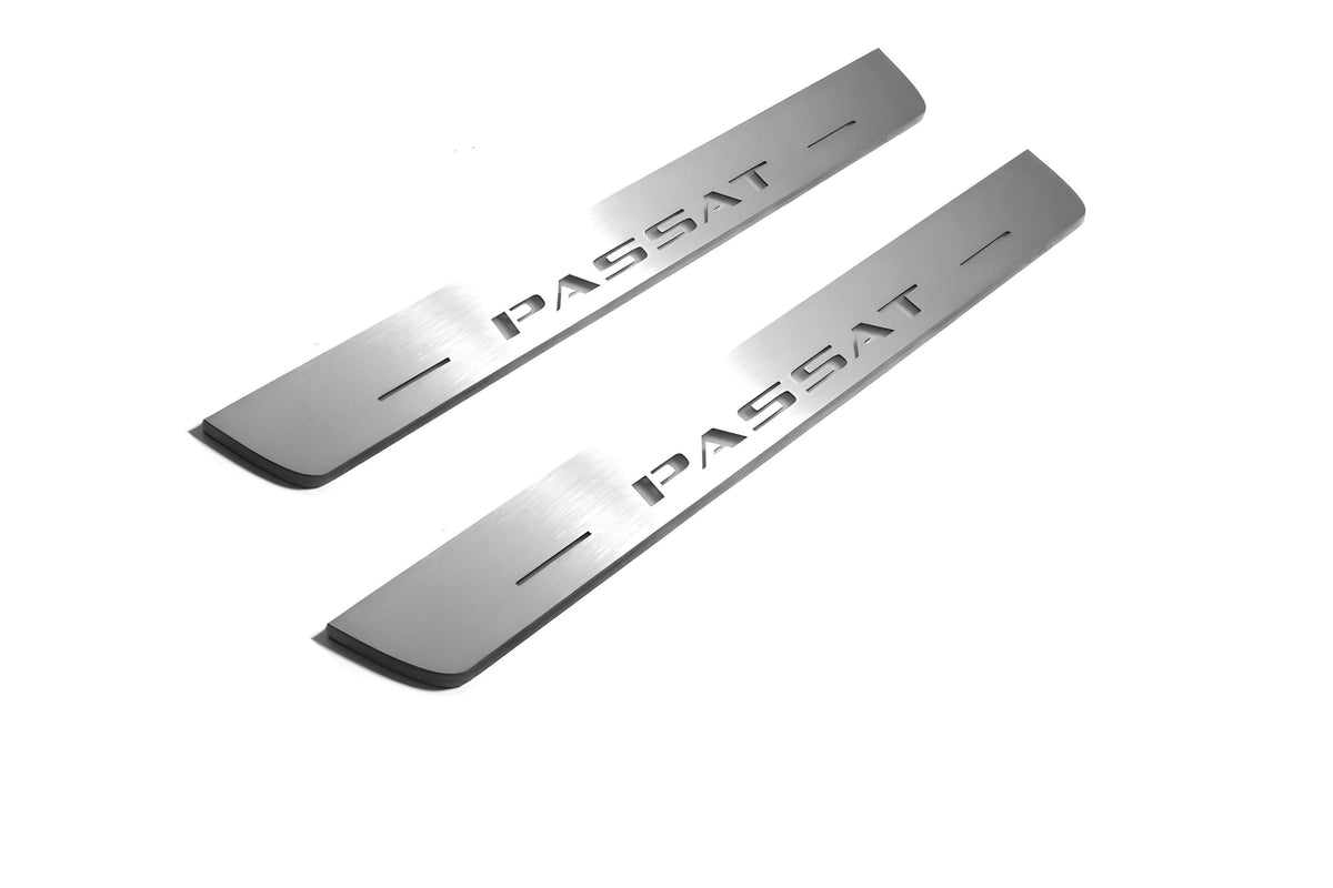 Two short silver-finished door sill plates with Passat lettering on a light background, angled view.