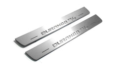 Two long silver-finished door sill plates with Durango R/T lettering on a light background, angled view.