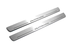 Two long silver-finished door sill plates with Outback lettering on a light background, angled view.