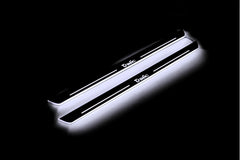 Two long door sill plates with Trafic lettering and edges illuminated in white, angled view on a dark background.
