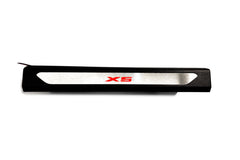 Black molded threshold trim with a silver insert bearing red X5 lettering, straight-on view on a white background.