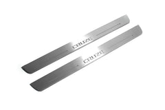 Two long silver-finished door sill plates with Cruze lettering on a light background, angled view.