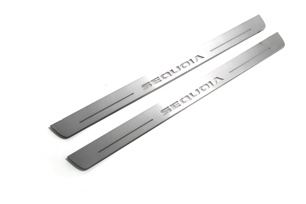 Two long silver-finished door sill plates with Sequoia lettering on a light background, angled view.