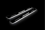 Two long door sill plates with Accent lettering and edges illuminated in white, angled view on a dark background.