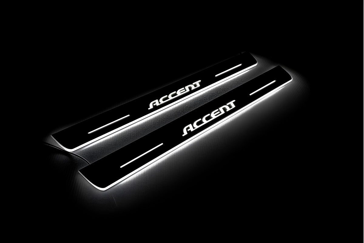 Two long door sill plates with Accent lettering and edges illuminated in white, angled view on a dark background.