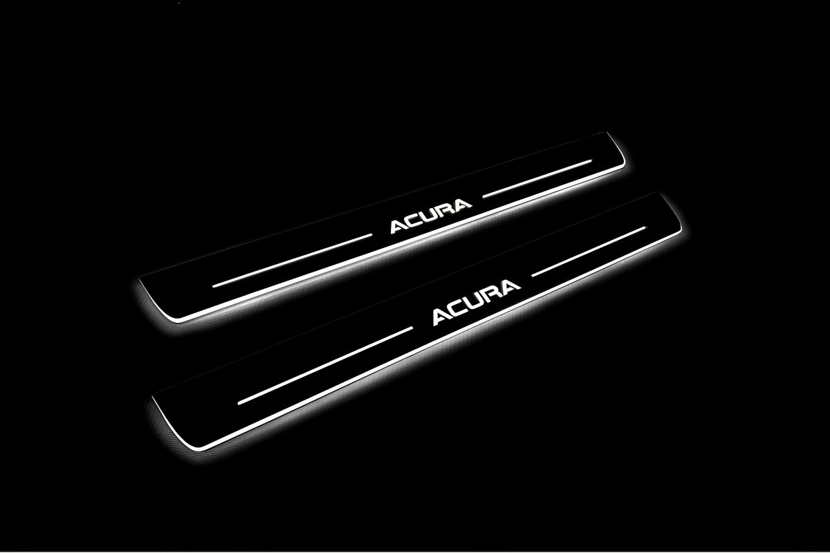 Two long door sill plates with Acura lettering and edges illuminated in white, angled view on a dark background.