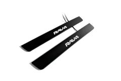 Two black door sill plates with white Rav4 lettering and visible wiring on a light background.