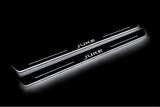 Two long door sill plates with Juke lettering and edges illuminated in white, angled view on a dark background.