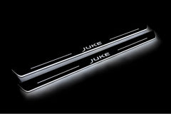 Two long door sill plates with Juke lettering and edges illuminated in white, angled view on a dark background.