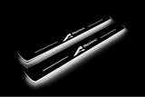 Two long door sill plates with A-Spec lettering and edges illuminated in white, angled view on a dark background.