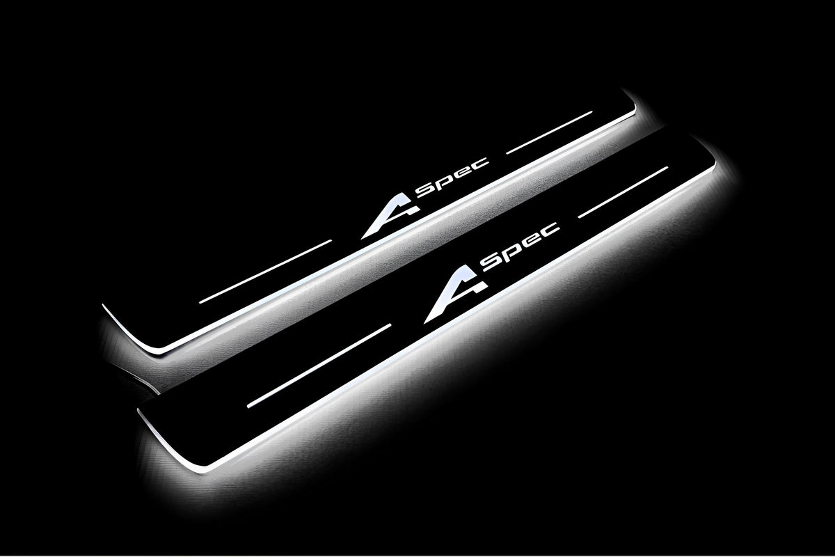 Two long door sill plates with A-Spec lettering and edges illuminated in white, angled view on a dark background.