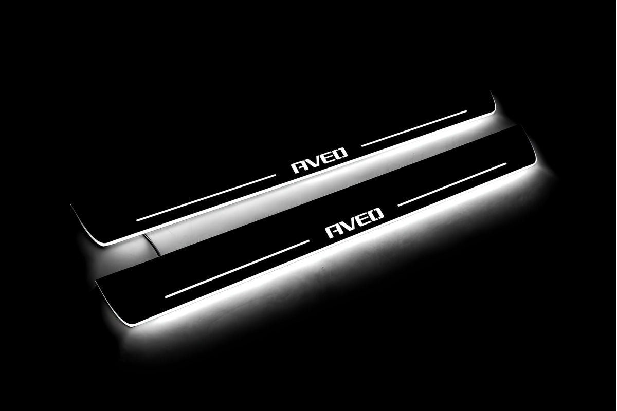 Two long door sill plates with Aveo lettering and edges illuminated in white, angled view on a dark background.