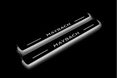 Two long door sill plates with Maybach lettering and edges illuminated in white, angled view on a dark background.