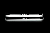 Two long door sill plates with ID.4 lettering and edges illuminated in white, straight-on view on a dark background.