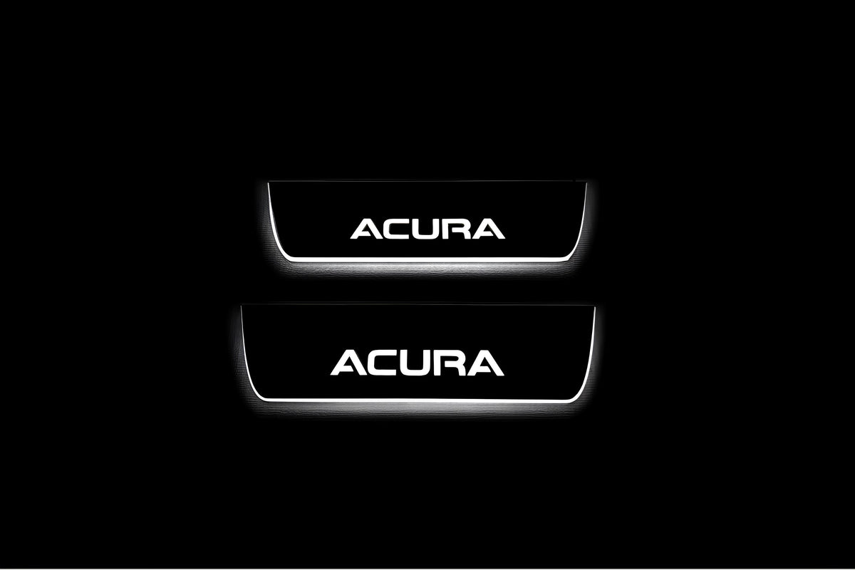 Two short door sill plates with Acura lettering and edges illuminated in white, straight-on view on a dark background.