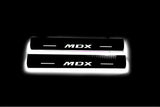 Two short door sill plates with MDX lettering and edges illuminated in white, straight-on view on a dark background.