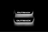 Two short door sill plates with Outback lettering and edges illuminated in white, straight-on view on a dark background.