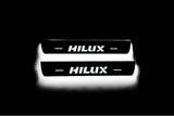 LED door sill plates Toyota Hilux VIII 2015+ stainless steel with Hilux logo