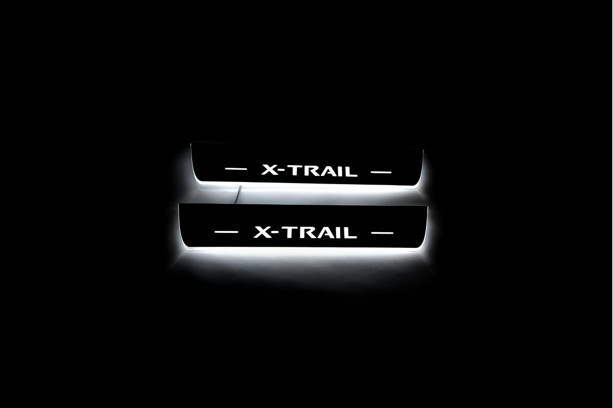 Two short door sill plates with X-Trail lettering and edges illuminated in white, straight-on view on a dark background.