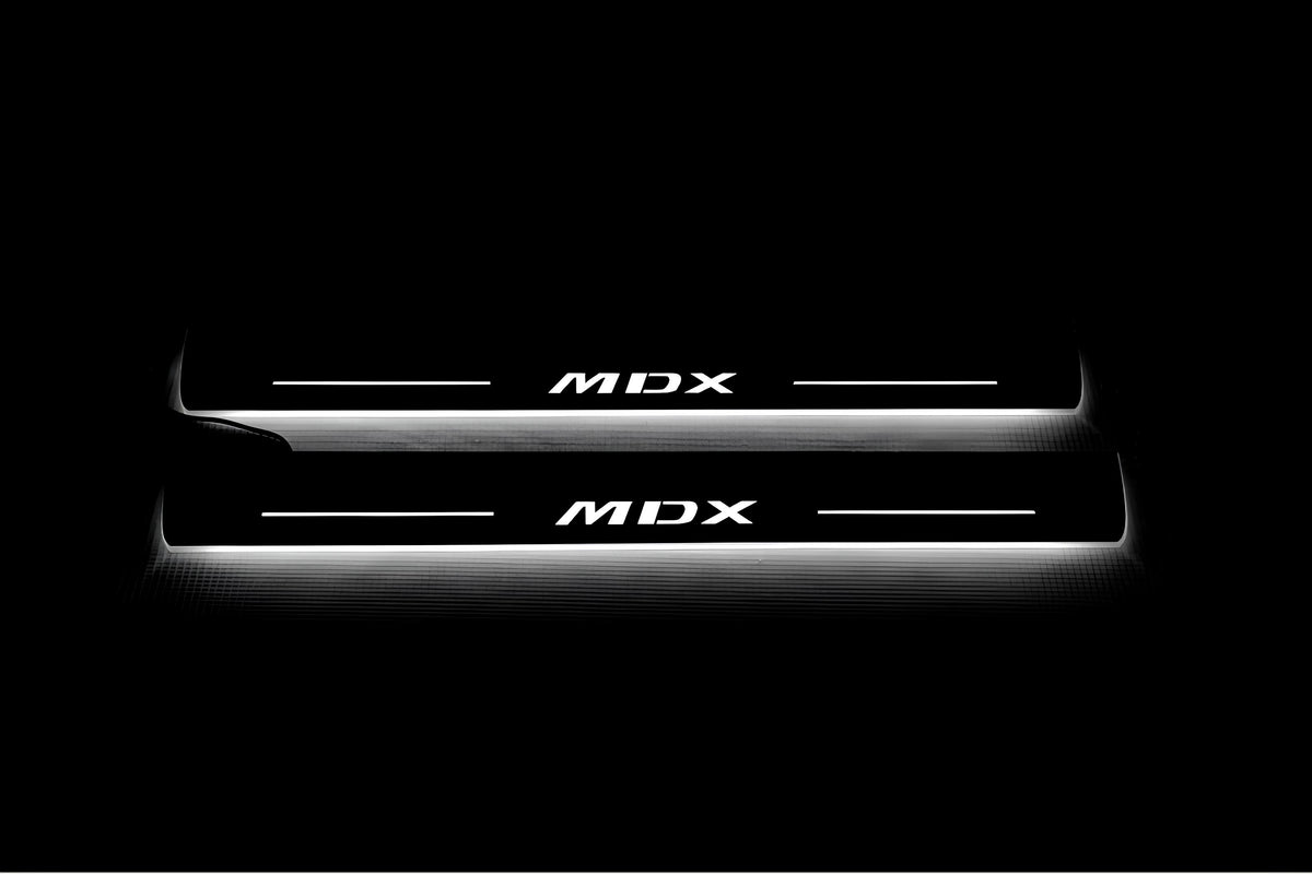 Two long door sill plates with MDX lettering and edges illuminated in white, straight-on view on a dark background.