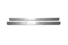 Two long silver-finished door sill plates with Range Rover lettering on a light background, straight-on view.