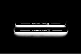 Two long door sill plates with Grandland X lettering and edges illuminated in white, straight-on view on a dark background.